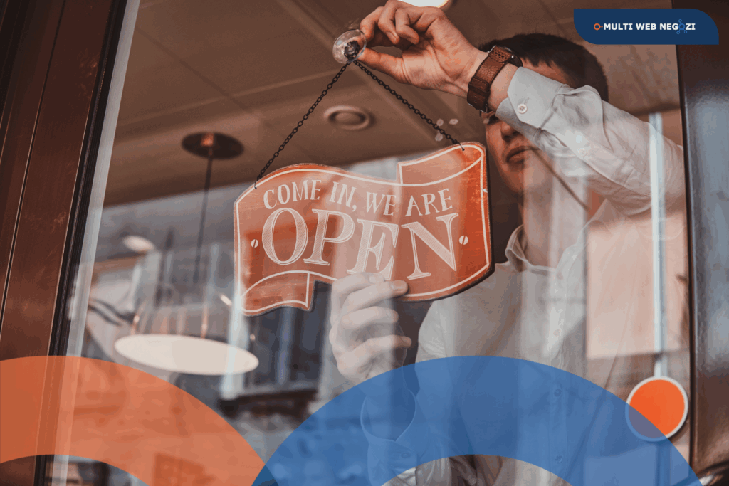 Commerciante che appende un cartello “Open” alla vetrina del negozio, simbolo di nuova apertura e ripartenza.